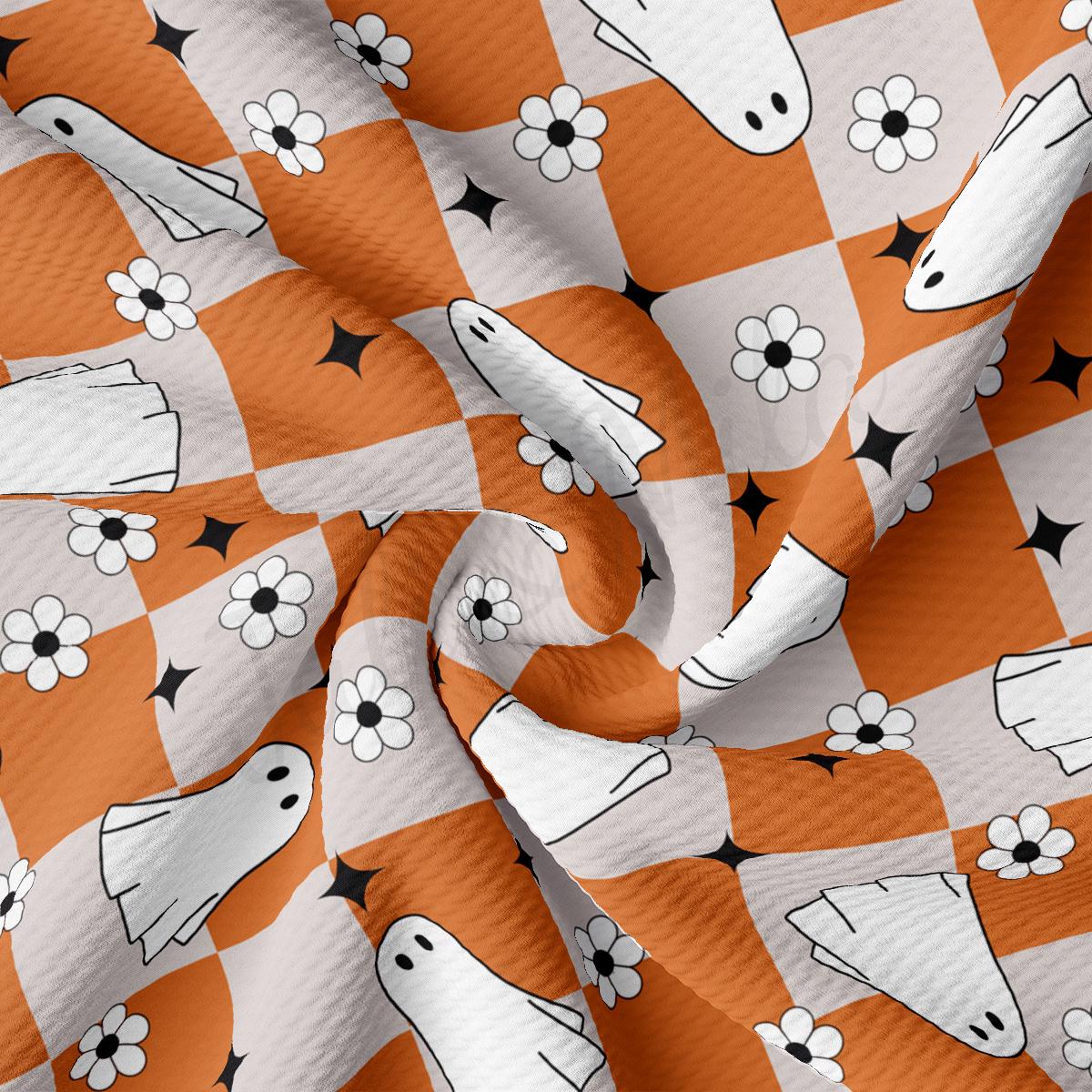 an orange and white checkered fabric with black and white flowers