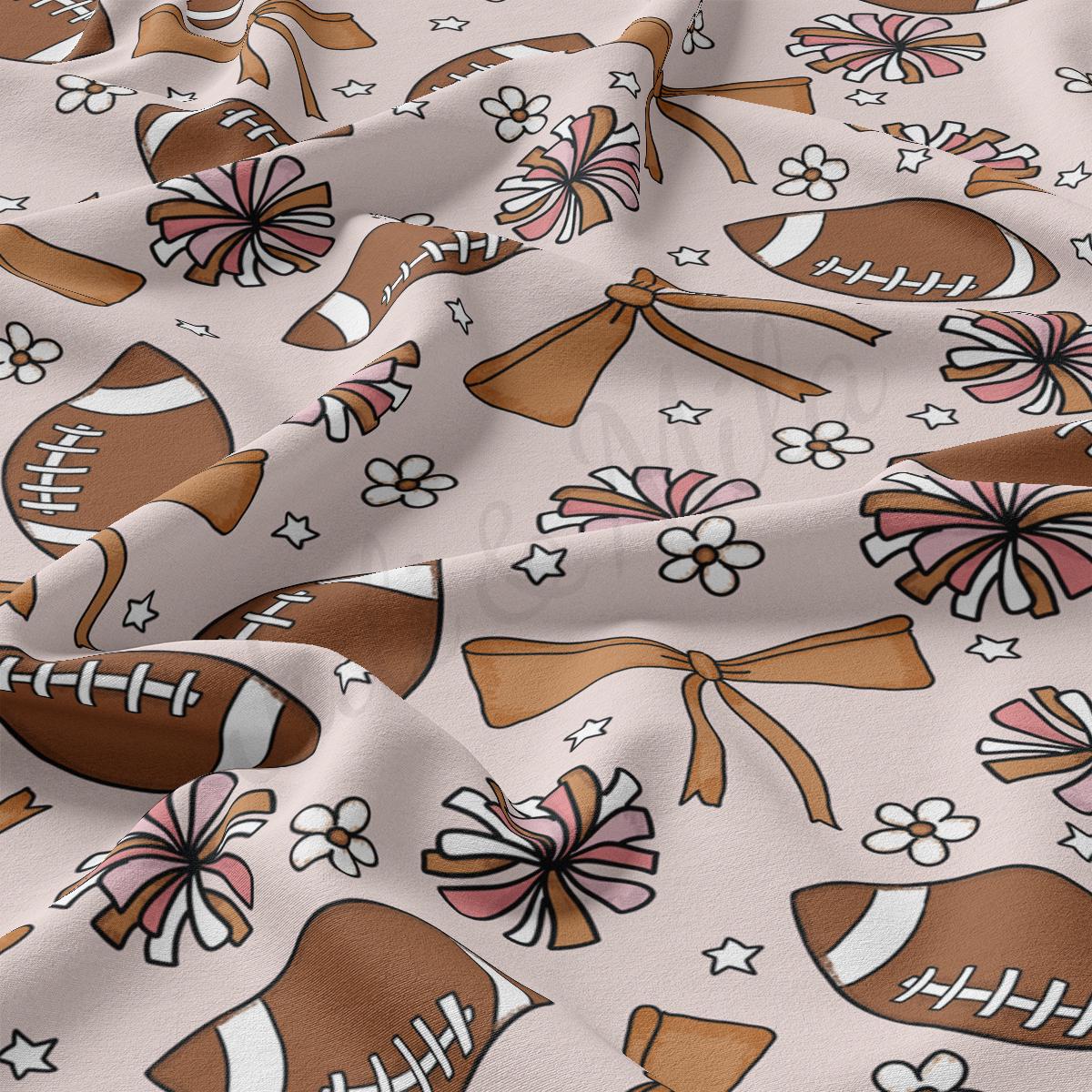 a fabric with a pattern of footballs and bows