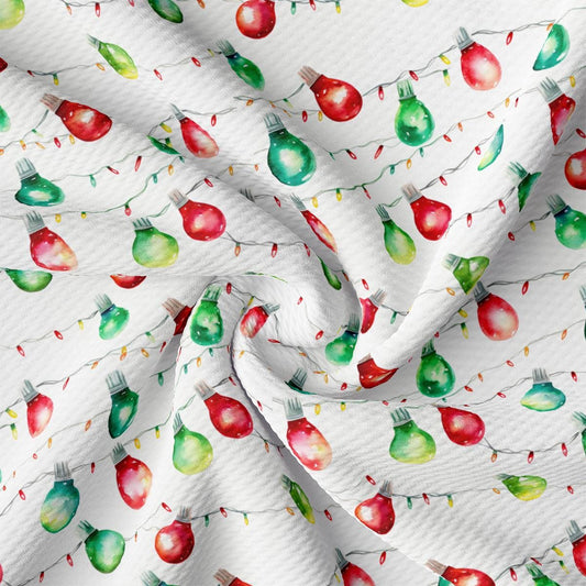 a close up of a white fabric with red and green apples on it