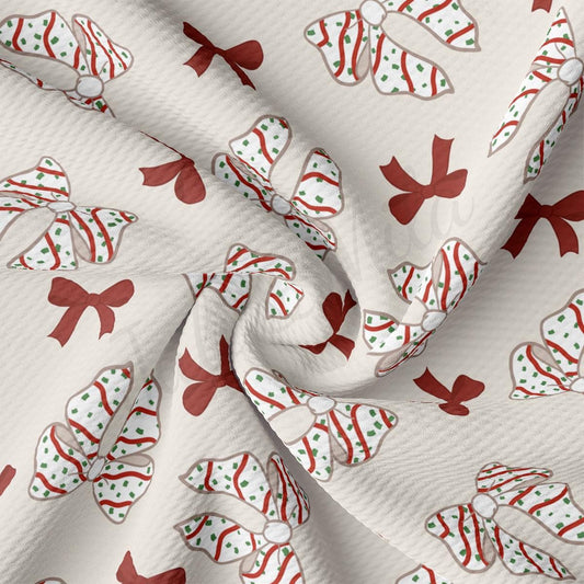 a close up of a white fabric with red and green bows