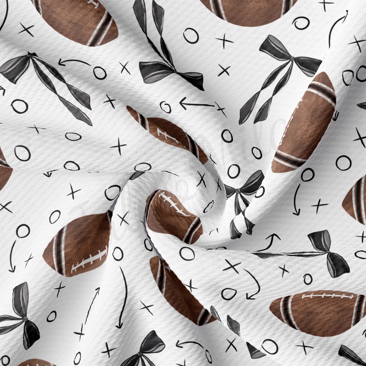 a white fabric with brown and black footballs on it