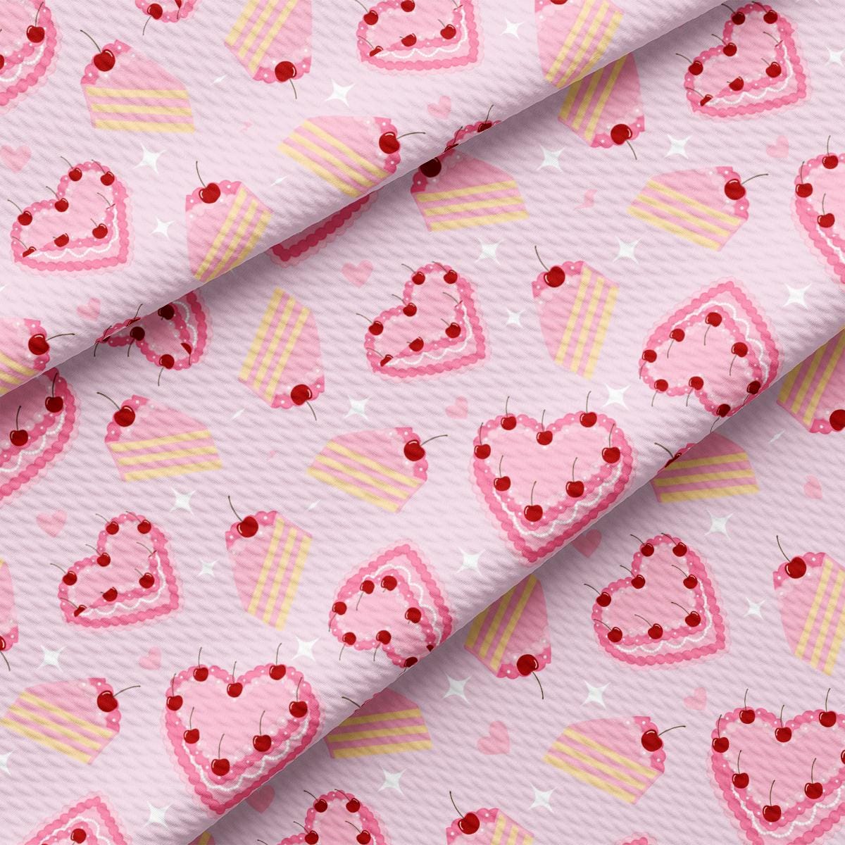 a pink fabric with hearts and cupcakes on it